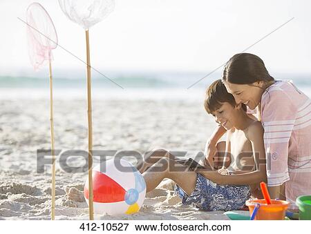 Mother and son relaxing on beach View Large Photo Image Stock Photo - Mother and son relaxing on beach. Fotosearch