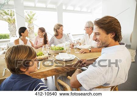 Multi-generation family eating together at table View Large Photo Image Stock Image - Multi-generation family eating together at table. Fotosearch