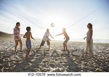 Multi-generation family playing volleyball on beach View Large Photo Image Stock Photo - Multi-generation family playing volleyball on beach. Fotosearch