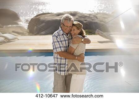 Older couple hugging by pool View Large Photo Image Stock Photo - Older couple hugging by pool. Fotosearch