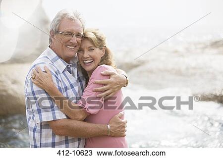 Older couple hugging on beach View Large Photo Image Stock Image - Older couple hugging on beach. Fotosearch