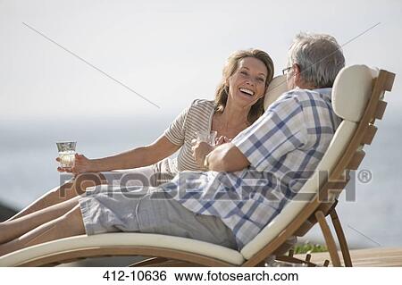 Stock Photograph - Older couple relaxing in lawn chairs. Fotosearch