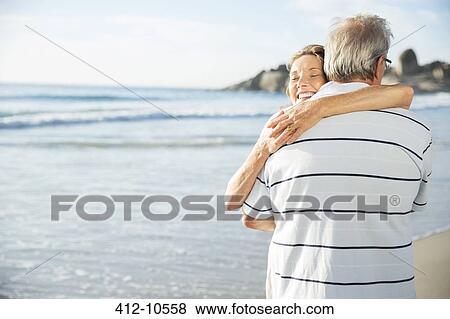 Senior couple hugging on beach View Large Photo Image Stock Photo - Senior couple hugging on beach. Fotosearch