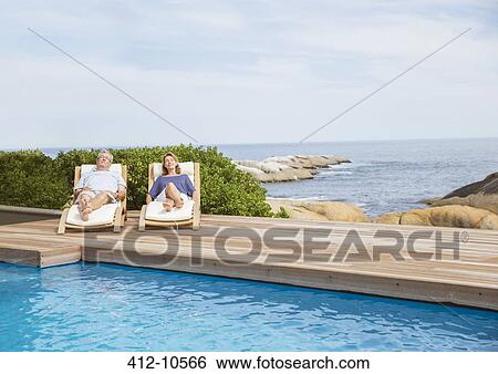 Senior couple relaxing at poolside View Large Photo Image Stock Photograph - Senior couple relaxing at poolside. Fotosearch