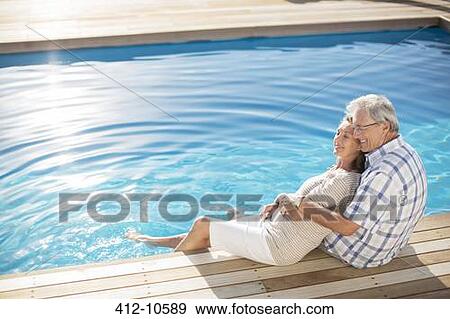 Senior couple relaxing by pool View Large Photo Image Stock Photo - Senior couple relaxing by pool. Fotosearch