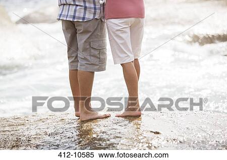 Senior couple standing on rock at beach View Large Photo Image Stock Photography - Senior couple standing on rock at beach. Fotosearch