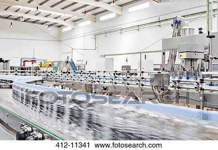 Stock Image - Bottles on conveyor belt in factory. Fotosearch