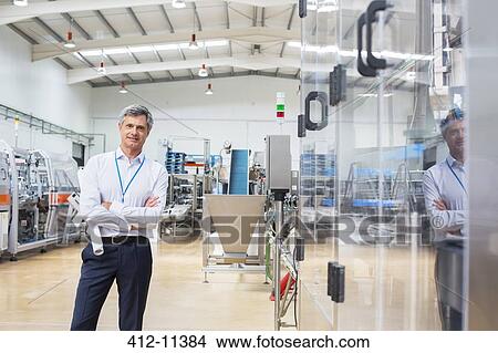 Picture - Businessman smiling in factory. Fotosearch