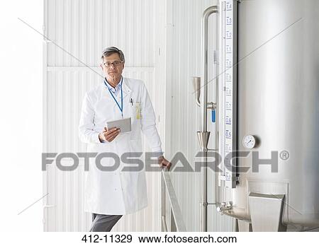 Scientist smiling in food processing plant View Large Photo Image Stock Photo - Scientist smiling in food processing plant. Fotosearch