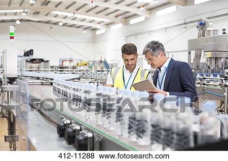 Supervisor and manager watching plastic bottles on conveyor belt View Large Photo Image Stock Photo - Supervisor and manager watching plastic bottles on conveyor belt. Fotosearch