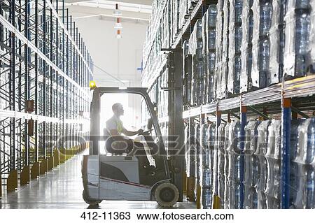 Worker operating forklift in warehouse View Large Photo Image Stock Image - Worker operating forklift in warehouse. Fotosearch