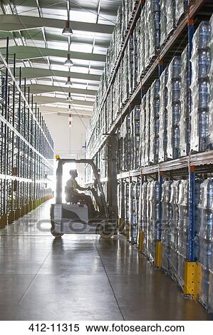 Stock Photography - Worker operating forklift in warehouse. Fotosearch