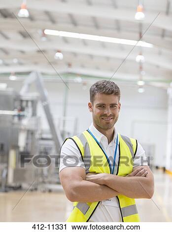 Stock Image - Worker smiling in factory. Fotosearch