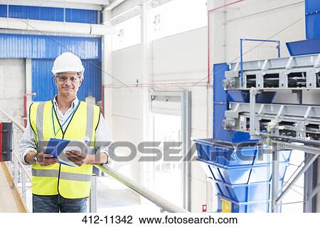 Worker smiling in factory View Large Photo Image Stock Image - Worker smiling in factory. Fotosearch