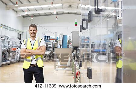 Stock Photo - Worker smiling in factory. Fotosearch