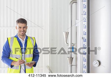 Worker smiling in factory View Large Photo Image Stock Photography - Worker smiling in factory. Fotosearch