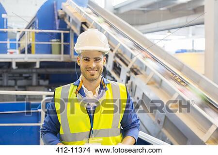Worker smiling in recycling center View Large Photo Image Picture - Worker smiling in recycling center. Fotosearch