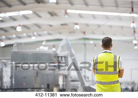 Worker standing in factory View Large Photo Image Stock Image - Worker standing in factory. Fotosearch