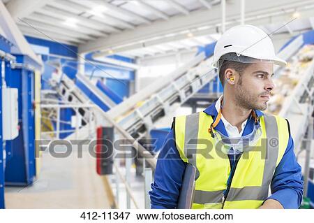 Stock Photo - Worker standing in factory. Fotosearch