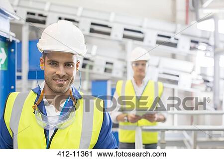 Workers smiling in factory View Large Photo Image Stock Image - Workers smiling in factory. Fotosearch
