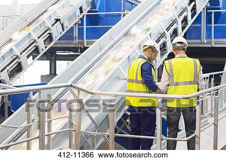 Stock Photograph - Workers talking in recycling center. Fotosearch