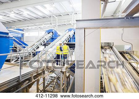 Workers talking on platform in recycling center View Large Photo Image Stock Photo - Workers talking on platform in recycling center. Fotosearch