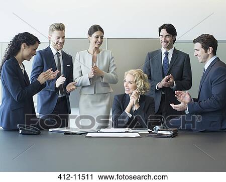 Stock Image - Business people cheering in meeting. Fotosearch