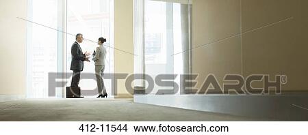 Business people talking at office window View Large Photo Image Picture - Business people talking at office window. Fotosearch