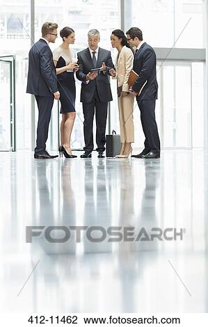 Business people talking in office lobby View Large Photo Image Stock Image - Business people talking in office lobby. Fotosearch