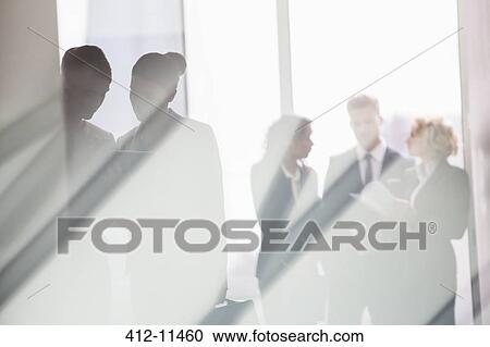 Business people talking in sunny office View Large Photo Image Stock Image - Business people talking in sunny office. Fotosearch