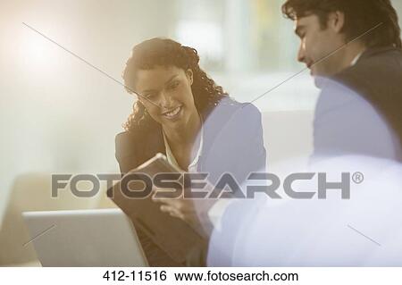 Stock Photograph - Business people using digital tablet in office. Fotosearch