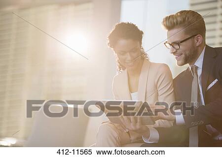 Business people using digital tablet in office View Large Photo Image Stock Photography - Business people using digital tablet in office. Fotosearch