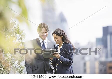 Business people using digital tablet outdoors View Large Photo Image Stock Photo - Business people using digital tablet outdoors. Fotosearch