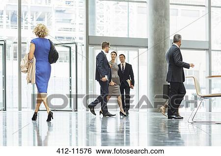 Business people walking in office lobby View Large Photo Image Stock Photograph - Business people walking in office lobby. Fotosearch