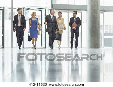Business people walking in office View Large Photo Image Stock Image - Business people walking in office. Fotosearch