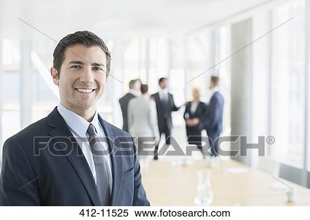Businessman smiling in office View Large Photo Image Stock Photography - Businessman smiling in office. Fotosearch