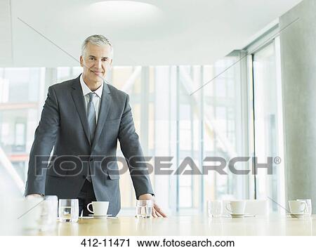 Stock Image - Businessman standing in office. Fotosearch