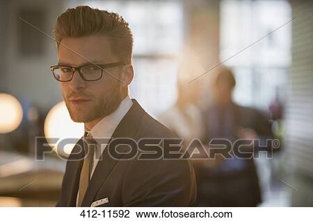 Stock Image - Businessman standing in office. Fotosearch