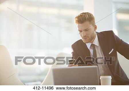 Businessman using cell phone in office View Large Photo Image Stock Photograph - Businessman using cell phone in office. Fotosearch