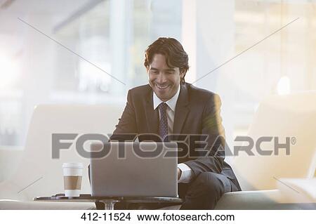 Picture - Businessman using laptop in office. Fotosearch