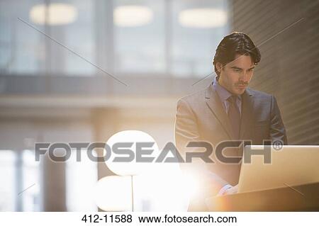 Businessman using laptop in office View Large Photo Image Stock Photo - Businessman using laptop in office. Fotosearch