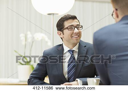 Businessmen talking in office View Large Photo Image Stock Photograph - Businessmen talking in office. Fotosearch