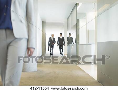 Picture - Businessmen walking in office corridor. Fotosearch