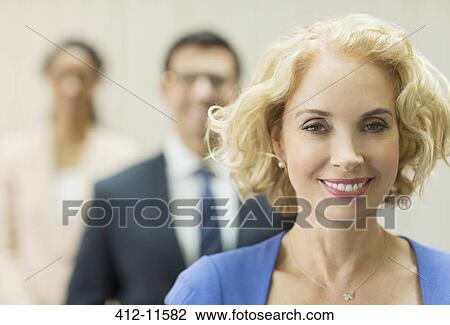 Stock Image - Businesswoman smiling in office. Fotosearch