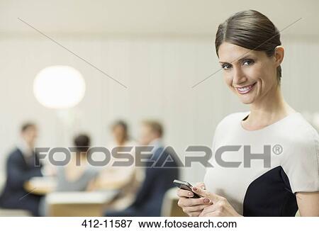 Businesswoman using cell phone in office View Large Photo Image Stock Photo - Businesswoman using cell phone in office. Fotosearch