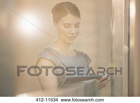 Picture - Businesswoman using digital tablet in office. Fotosearch