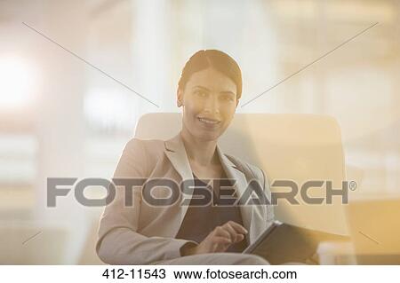 Businesswoman using digital tablet in office View Large Photo Image Stock Image - Businesswoman using digital tablet in office. Fotosearch