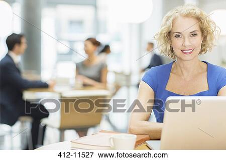 Stock Photo - Businesswoman using laptop in cafe. Fotosearch