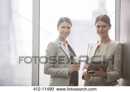 Businesswomen smiling in office View Large Photo Image Stock Image - Businesswomen smiling in office. Fotosearch