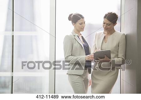 Businesswomen using digital tablet in office View Large Photo Image Stock Photo - Businesswomen using digital tablet in office. Fotosearch